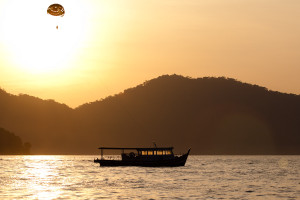 Práctica de parasailing durante el atardecer en Batu Ferringhi, isla de Penang, Malasia