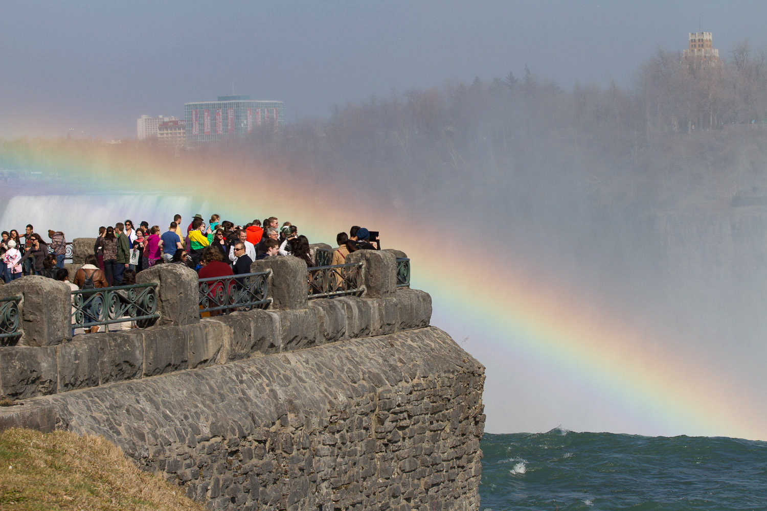 Turistas contemplando un arcoiris en las Horseshoe Falls, Niagara Falls, Canadá