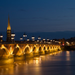 Vista nocturna del puente de piedra y la Basílica de San Miguel, Burdeos, Francia